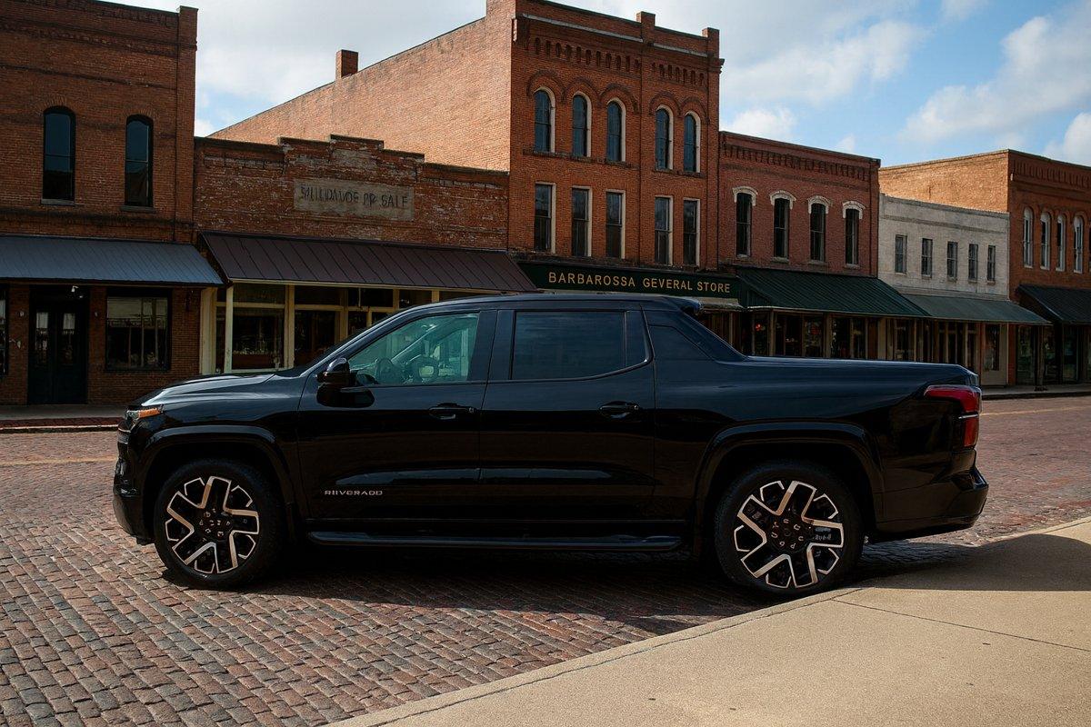 amioneta eléctrica Chevy Silverado EV RST negra estacionada en un antiguo centro histórico de Texas, ideal para ilustrar su diseño moderno y rendimiento.